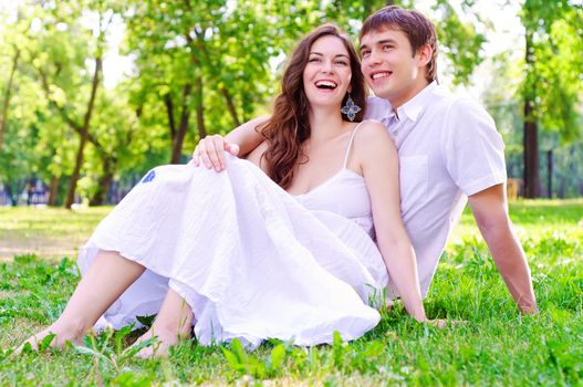 couple in the park sitting on the grass, have a good time together