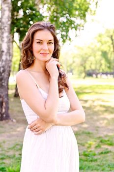 Portrait of an attractive woman in the park, crossed her arms