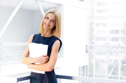 business woman holding reports and looking to the camera, copy space