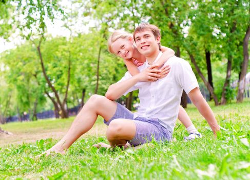 Father and daughter sitting together on the grass, and spend time with family