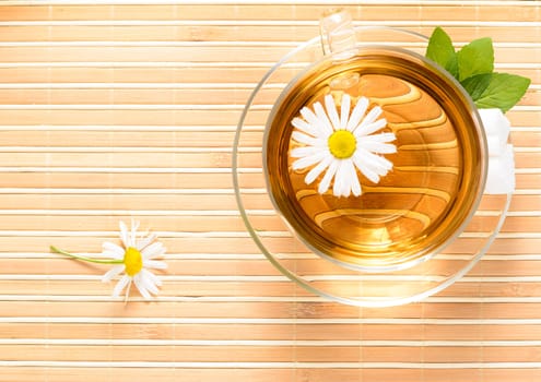 A teacup  with herbal chamomile tea and flower