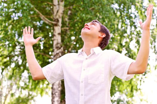 young man looking to the sky, holding his hands up, the expectation of success