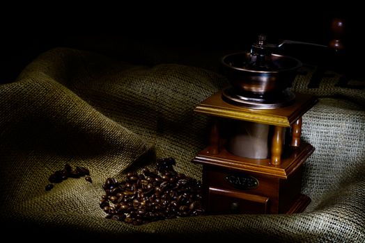 Coffee Mill with beans and burlap, emphasis rays of light