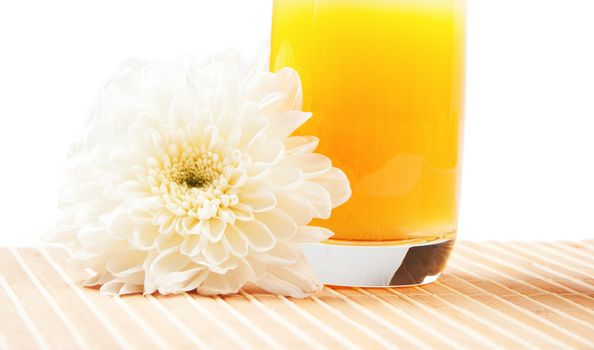 glass of orange juice and aster flower