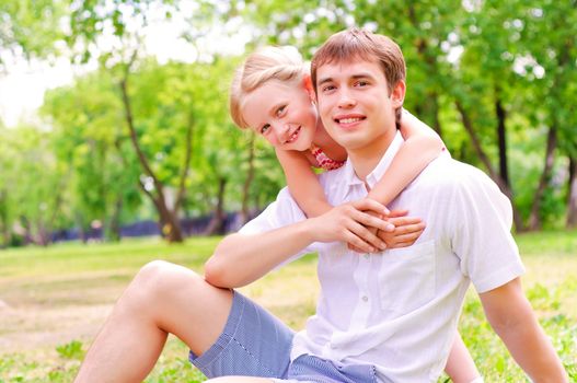 Father and daughter sitting together on the grass, and spend time with family