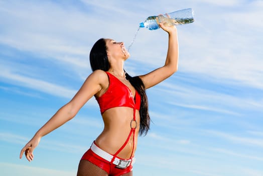 Young female sport girl in red uniform with a bottle of water