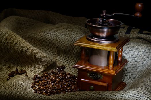 Coffee Mill with beans and burlap. still life