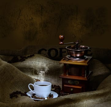 Coffee Mill with beans, cup and burlap. still life