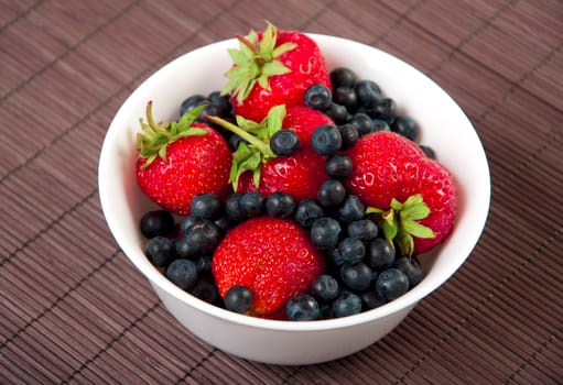 strawberries, bilberry  on bamboo tablecloth, still life