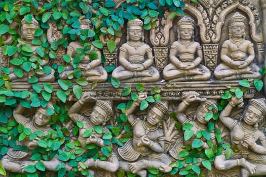 creeper plant groGreenwing on hindu statue