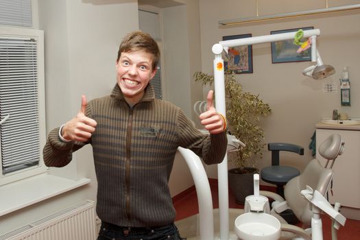 boy shows thumbs up after dentist visit
