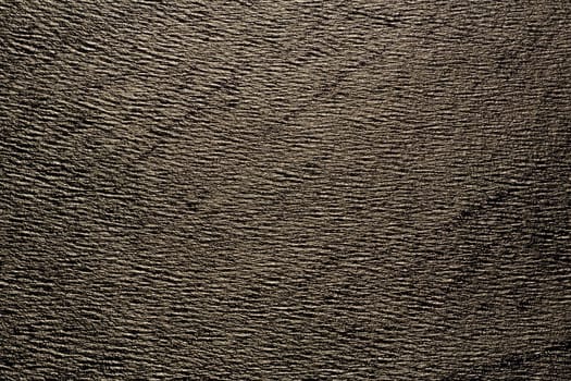 Texture of golden colored ocean waves seen from air lit by midnight sun 