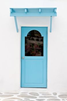 Blue door and sunshade on white house