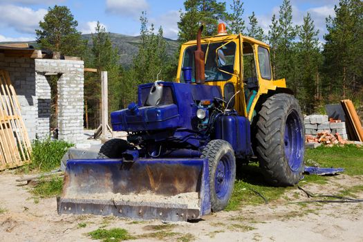 Old  tractor on a construction site. summer