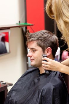 Young caucasian man being shaved in a hairdressing salon