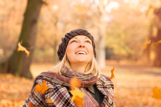 Young woman enjoying sunny day in autumn in the park