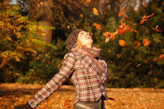Young woman enjoying sunny day in autumn in the park