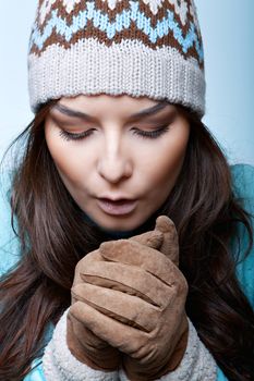 woman warm hands in gloves on a blue background