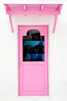 Pink door and sunshade on white house