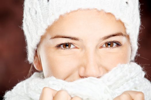 young happy brunette woman in wool sweater and cap, isolated on white