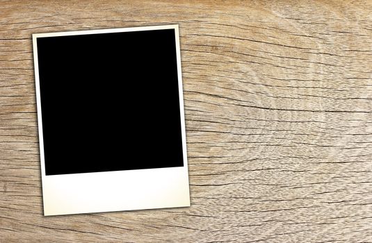 blank vintage paper and photo frame on wooden background