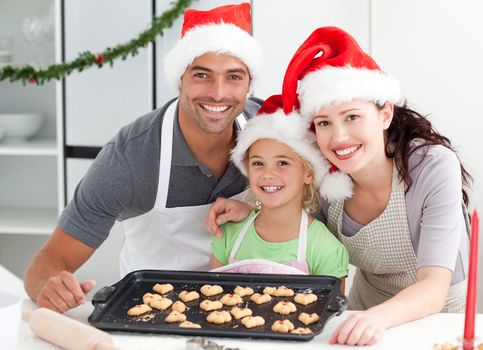 Happy woman with husband and daughter ith their biscuits ready to eat in the kitchen