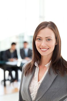 Attractive woman during a meeting with two businessmen sitting in the bakcground