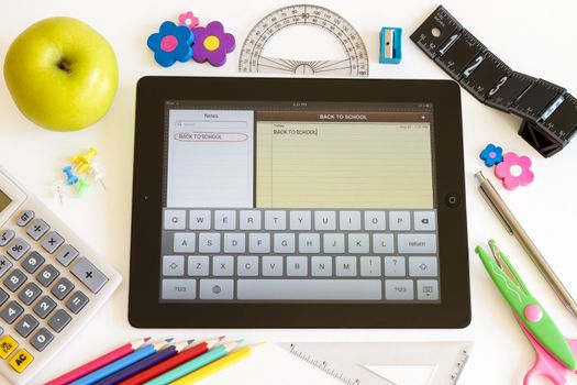 Ipad 3 with Notes application and school accesories on white