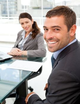 Cheerful business people sitting at a table with a laptop during a meeting 