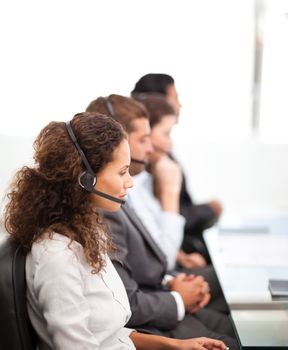 Four representatives on the phones with earpiece on sitting in their office