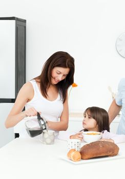 Mother and daughter having breakfast with their family in the kitchen 