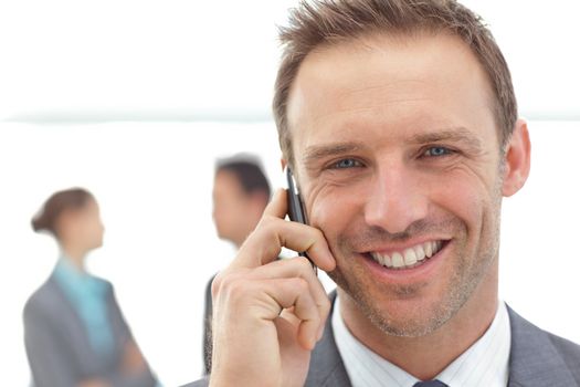 Portrait of a businessman on the phone during a meeting with his team 