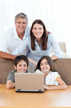 Joyful family looking at the camera at home