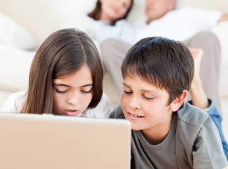 Lovely children watching a movie on their laptop at home