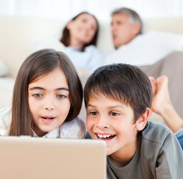 Lovely children watching a movie on their laptop at home