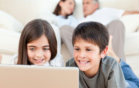 Lovely children watching a movie on their laptop at home