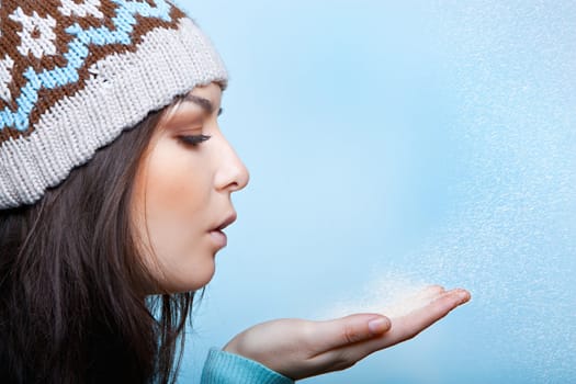 woman blows the snow on a blue background