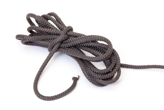 Roll of braided interwoven dark cord found in every household for general tying, securing and attachment of articles on a white background