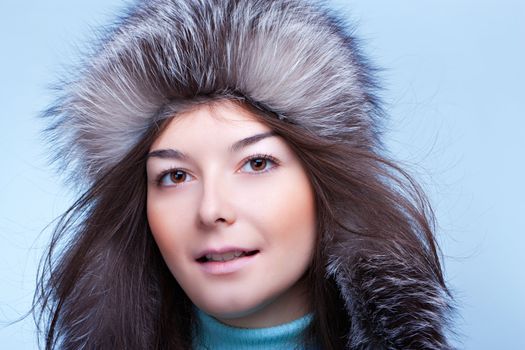 Smiling woman in a cap on the blue background