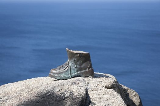 The bronze boot of Cape Finisterre, Spain marks the end of the pilgrimage and the pilgrims who have successfully completed the route of the Camino de Santiago. Here they burn their boots and clothes.
