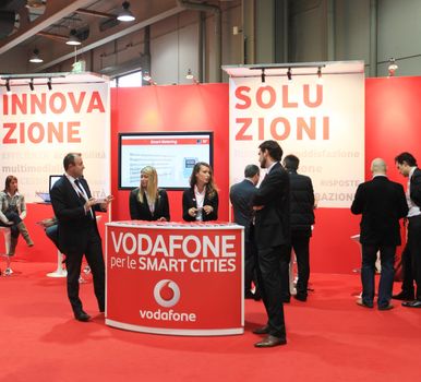 MILAN, ITALY - OCTOBER 17: People visit Vodafone technologies products exhibition area at SMAU, international fair of business intelligence and information technology October 17, 2012 in Milan, Italy.