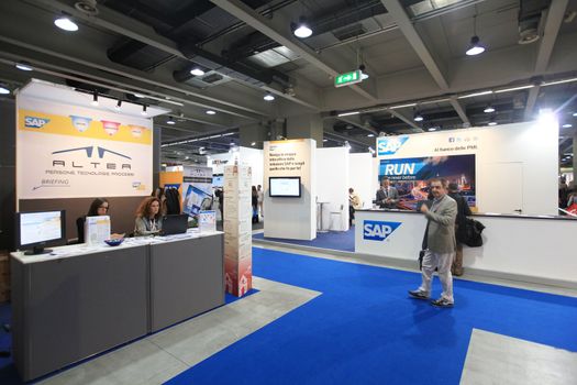 MILAN, ITALY - OCTOBER 17: People visit technologies products exhibition area at SMAU, international fair of business intelligence and information technology October 17, 2012 in Milan, Italy.