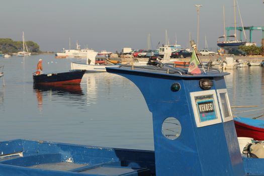 Fisherman coming back to the port, with island behind, in the south of Italy
