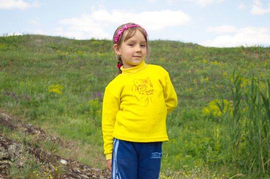 The Child on background of the nature, blue sky.