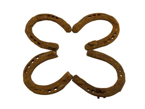 Concept of four leaf clover made of rusty retro horseshoes isolated on white background. Luck talisman.
