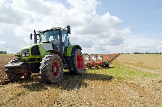 Closeup of tractor plowing agricultural field in autumn.