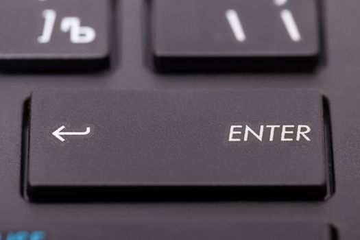 Closeup of an enter key on a computer keyboard or calculator with an arrow on the left