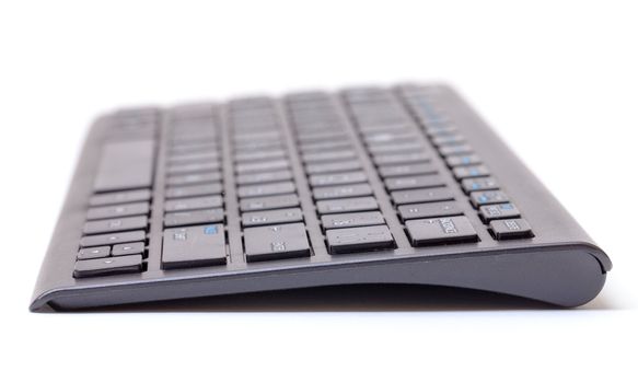 Low angle view of a computer keyboard lying end on the the camera with shallow dof over white