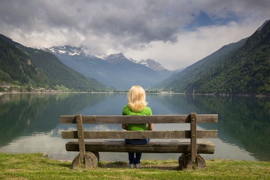 bench in the high mountains at the lake Poschiavo, Switzerland Alps