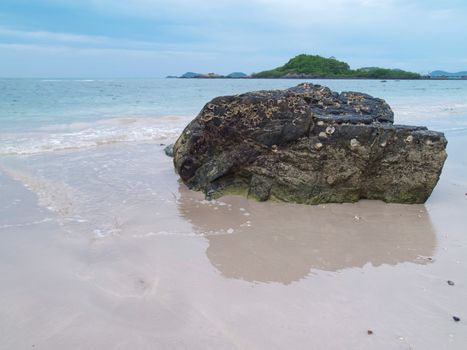 Stone with reflection on Nang Ram beach, Chon Buri, Thailand